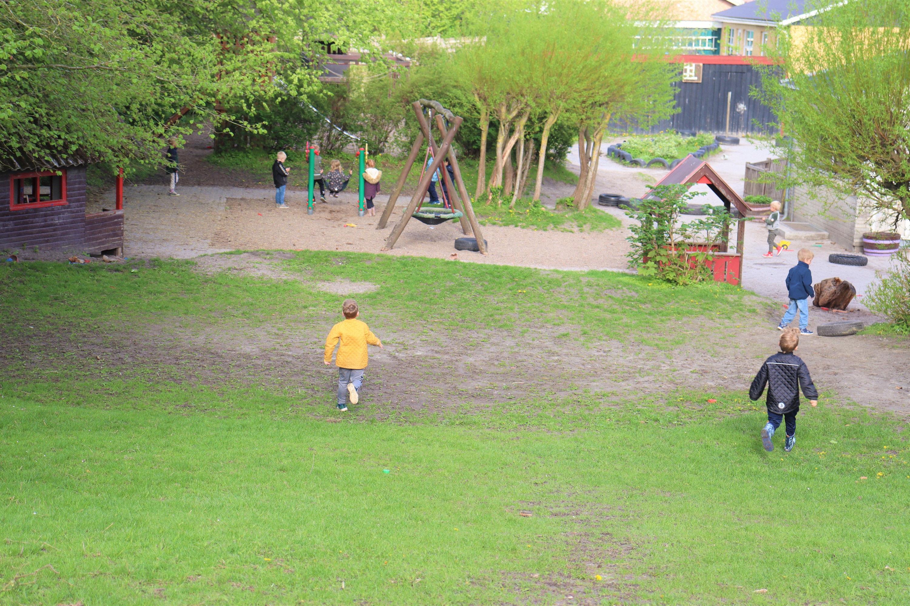 To børn løber ned græsbakke